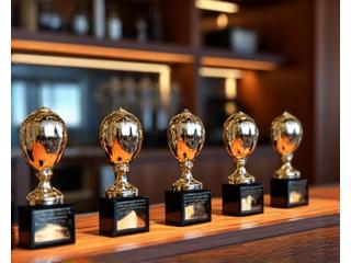 Image showing various culinary awards and trophies on display, with grilling equipment in the background.